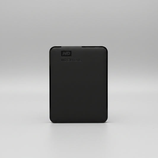 A black Western Digital WD Elements portable external hard drive standing upright on a wooden tabletop against a white paneled wall.